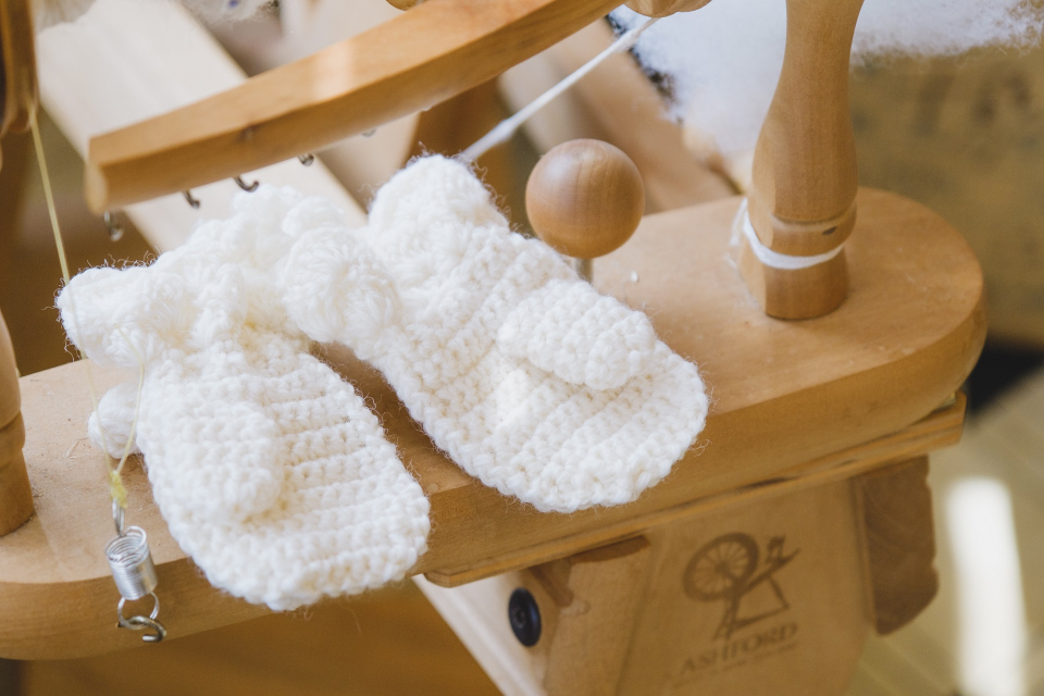めん羊布団と一緒に贈られる、赤ちゃん用の手編みの手袋
