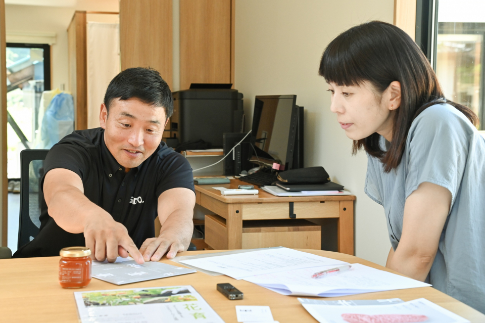 ロゴの説明をする智巳さんと佳子さん